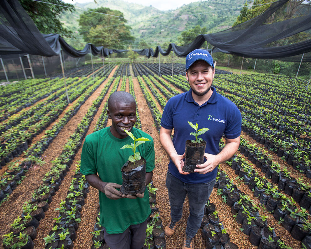 Two of our field team members with coffee seedlings in Uganda